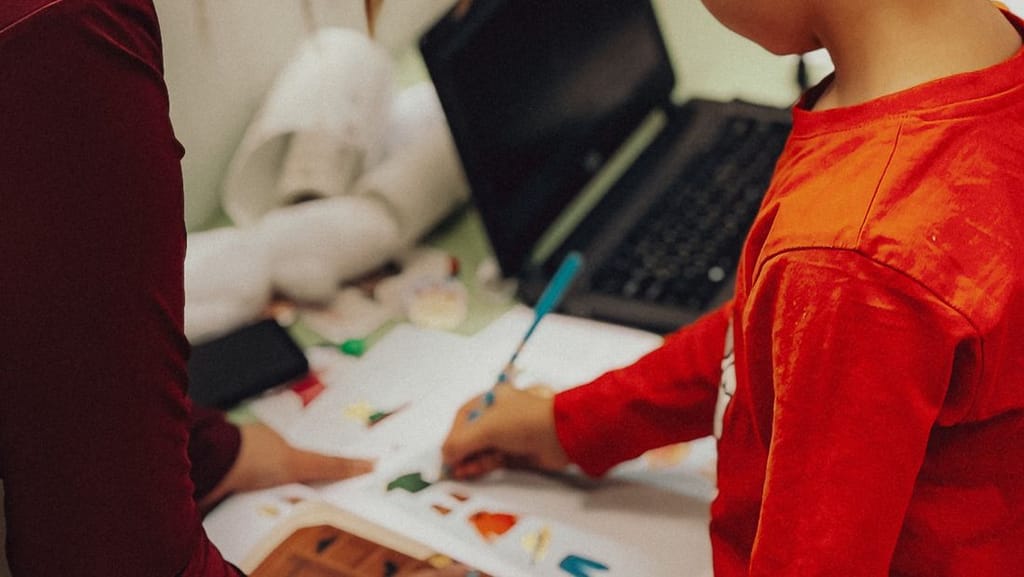 A child working on a hands-on learning activity with an adult helper, the kind of support required by special education laws