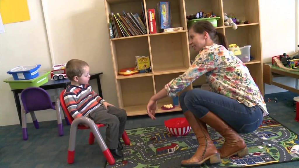 Therapist and child playing in a therapy room