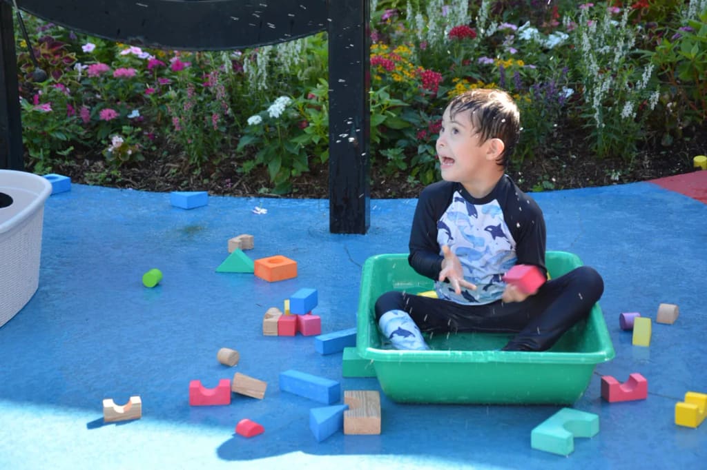 A student plays with blocks outdoors at Rise School of Houston
