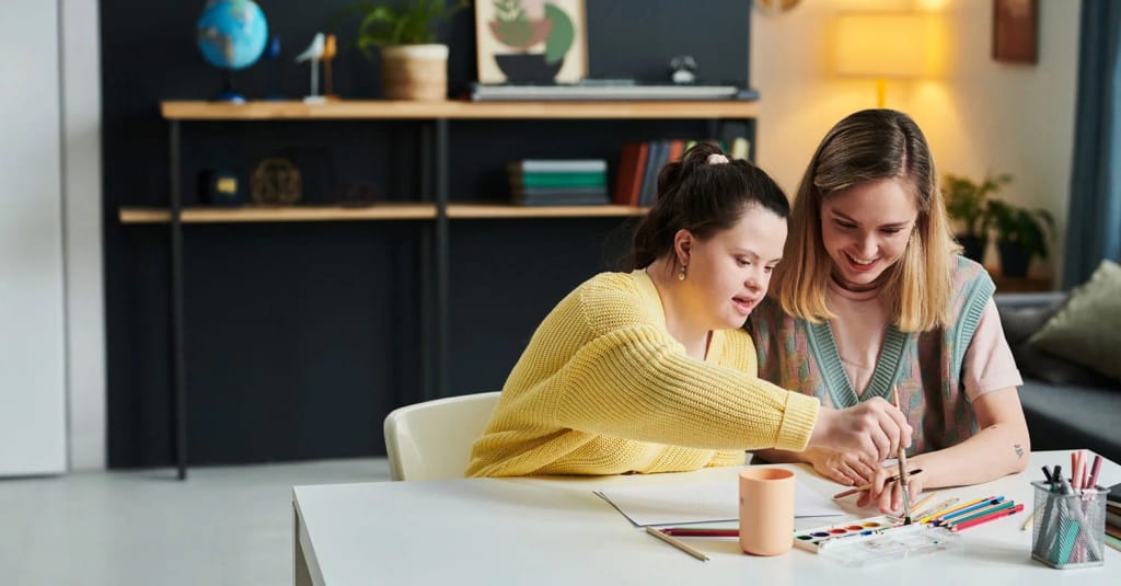 Adult supporting a person during a tabletop activity