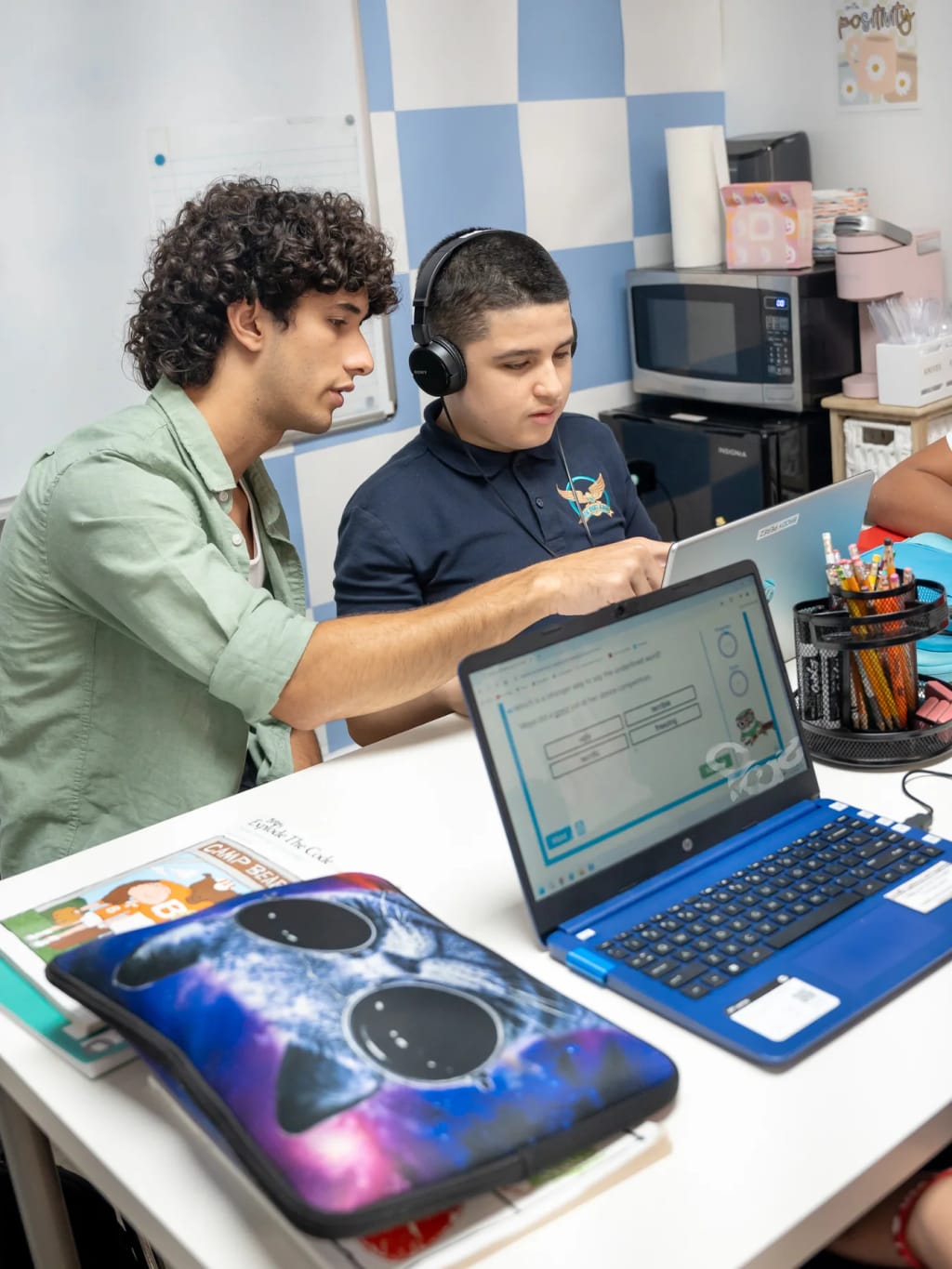 A teacher supports a Great Heights Academy student using classroom technology