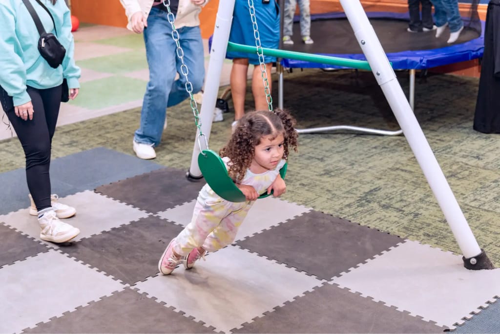 Child using a swing at Woven Care Central East