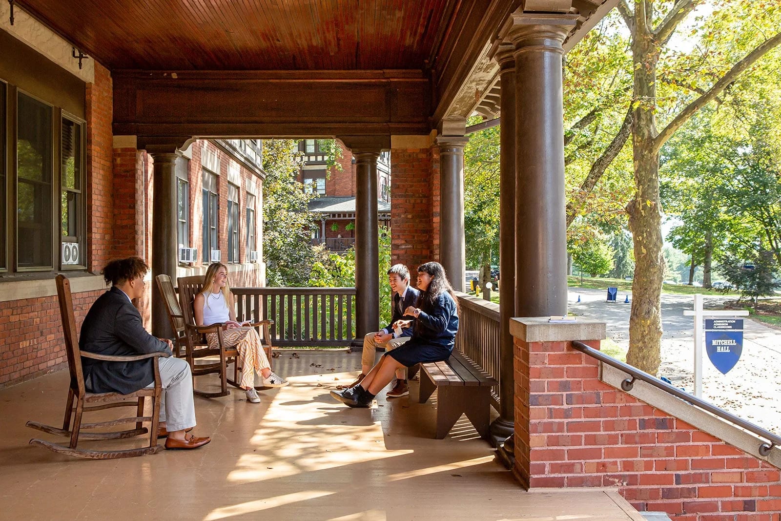 Asheville School students and staff gathered on a covered campus porch.