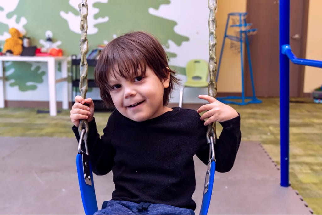 Child using a swing at Woven Care Woodmen