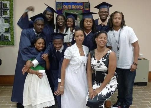 Graduates in caps and gowns with staff at The Monroe School, Inc.