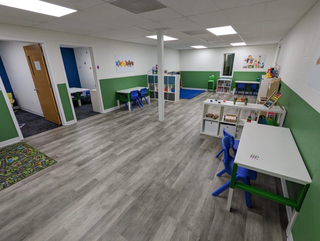 Learning area with child-sized tables and materials inside the HealthPRO Pediatrics Lakeland center.