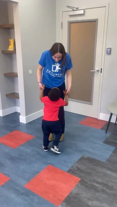 Therapist and child participating in a supported movement activity at Advanced Behavioral Therapy.