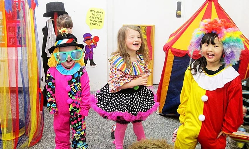A Child's Garden Preschool children smiling in colorful costumes indoors.