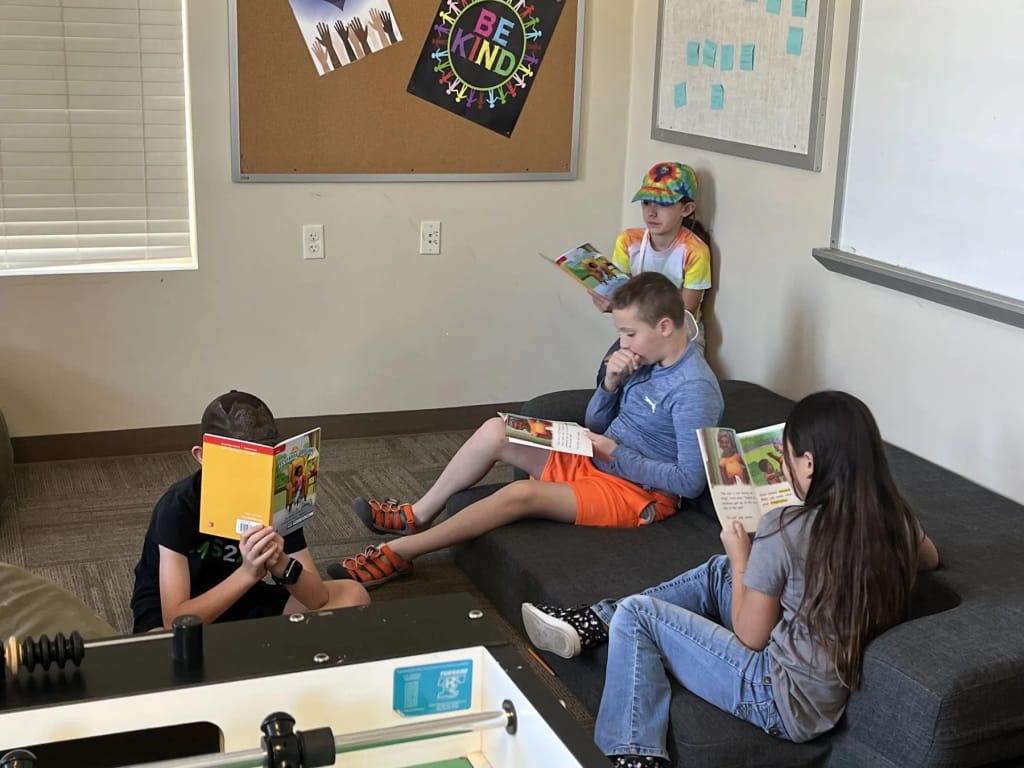 KoolMinds students and instructor working together in a classroom.
