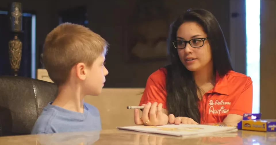 Arizona Autism therapist working with a child during a tabletop activity.