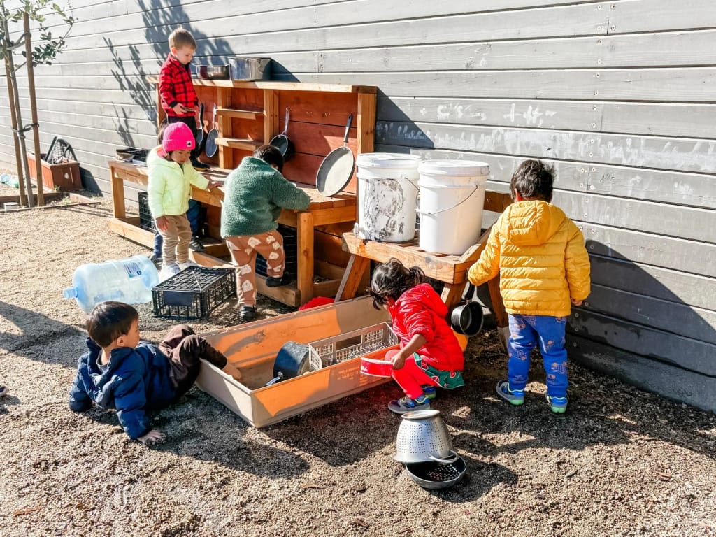 Lucciola Academy children playing at an outdoor sensory station