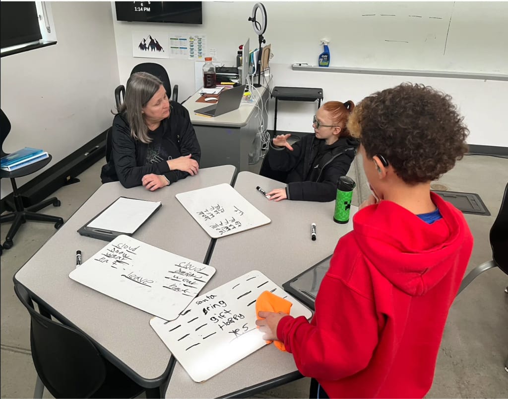 Teacher and students working together at Rocky Mountain Deaf School