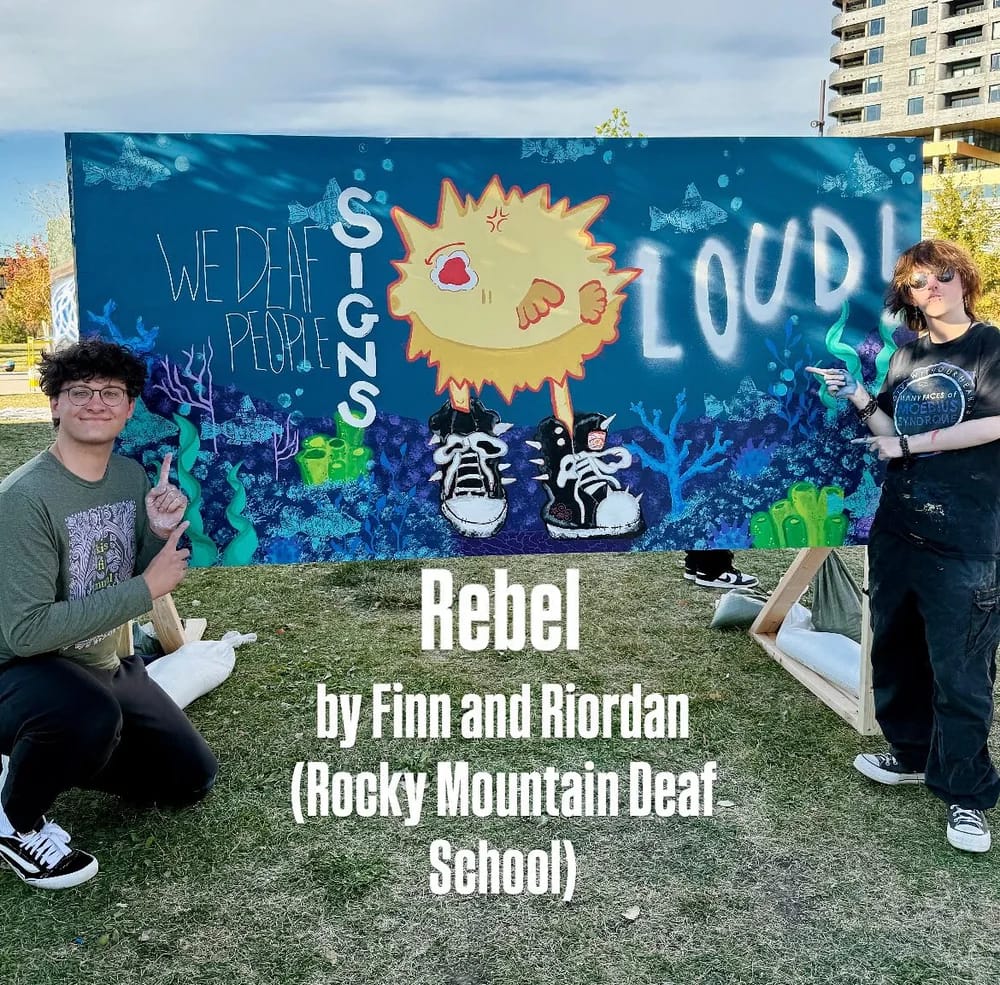 Rocky Mountain Deaf School students posing beside a colorful mural