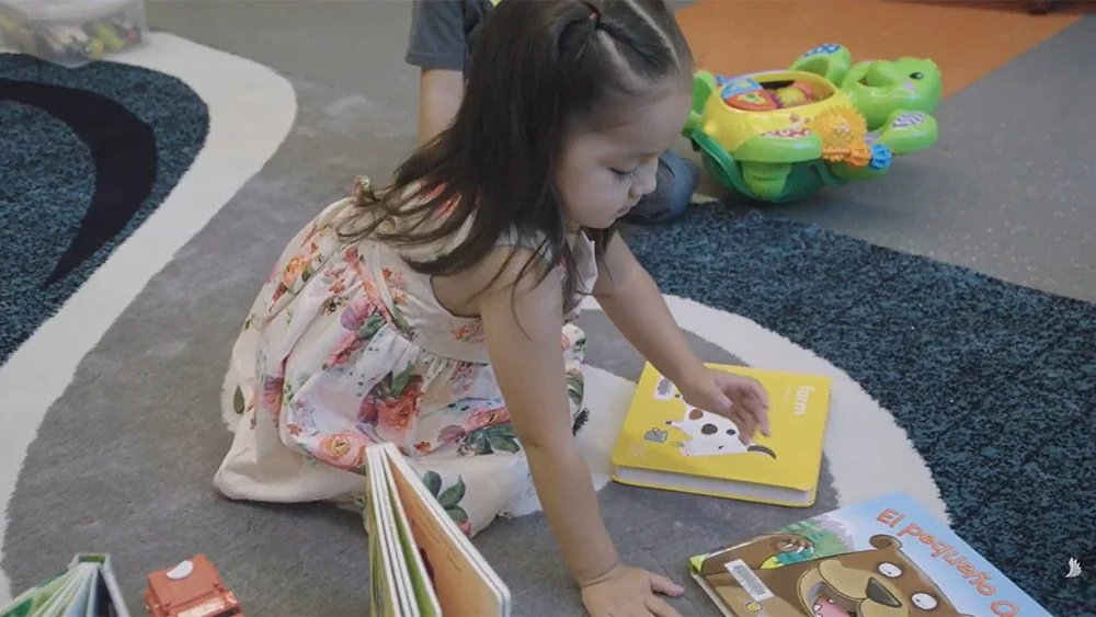 Young Laradon student looking through books in a classroom