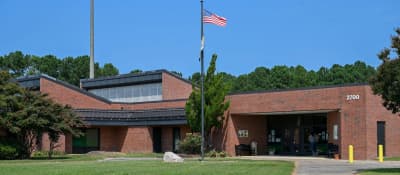 Front exterior of Benvenue Elementary School with its entrance and flagpole.