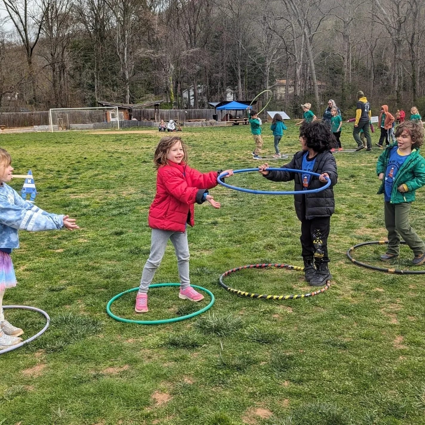 Evergreen Community Charter School students playing with hula hoops outdoors.