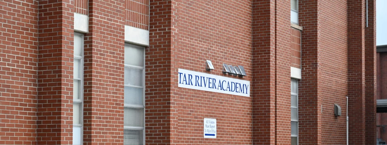 Tar River Academy building entrance with the school name displayed on the brick facade.