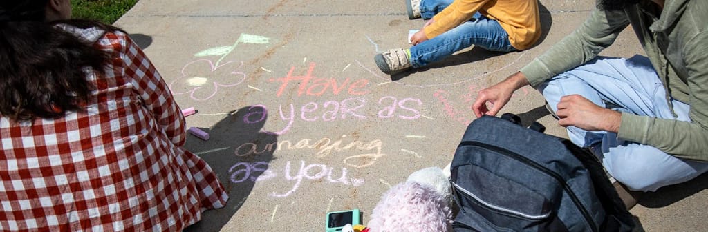 Samuelson Elementary students drawing with chalk outdoors
