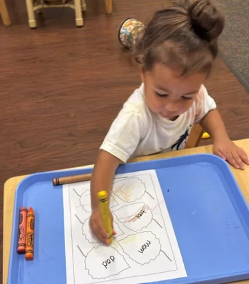 A young student completing a classroom activity at Heart of Hope Academy