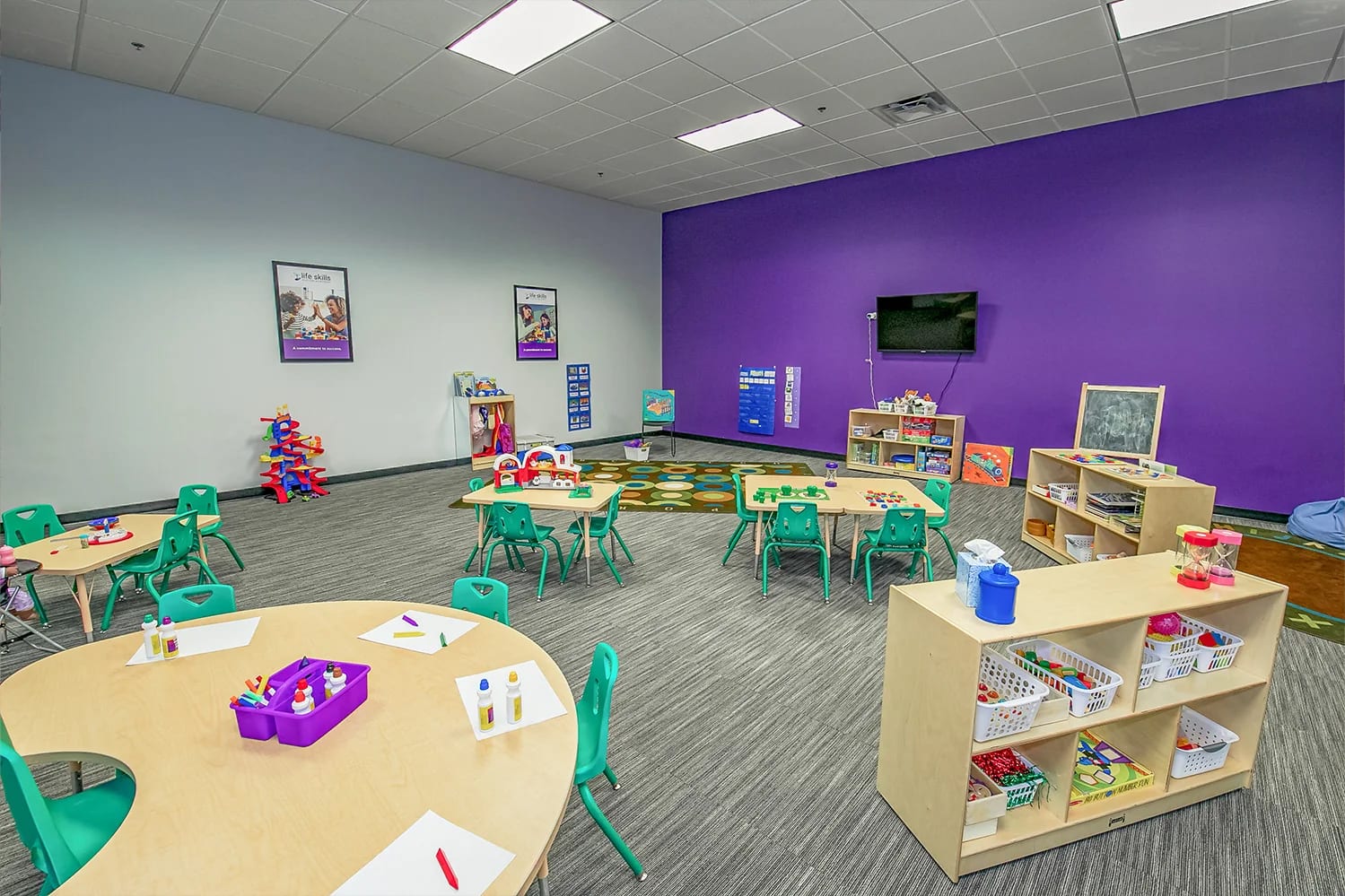 Colorful sensory room with child-sized tables and activity materials at Centria Autism.