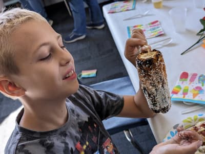 Kinship Academy student holding a decorated classroom treat