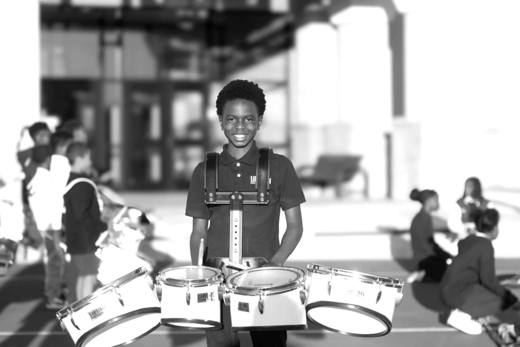 Liberty STEAM Charter School-Primary Academy in Sumter: Liberty STEAM Charter School scholar participating in a classroom drumming activity.