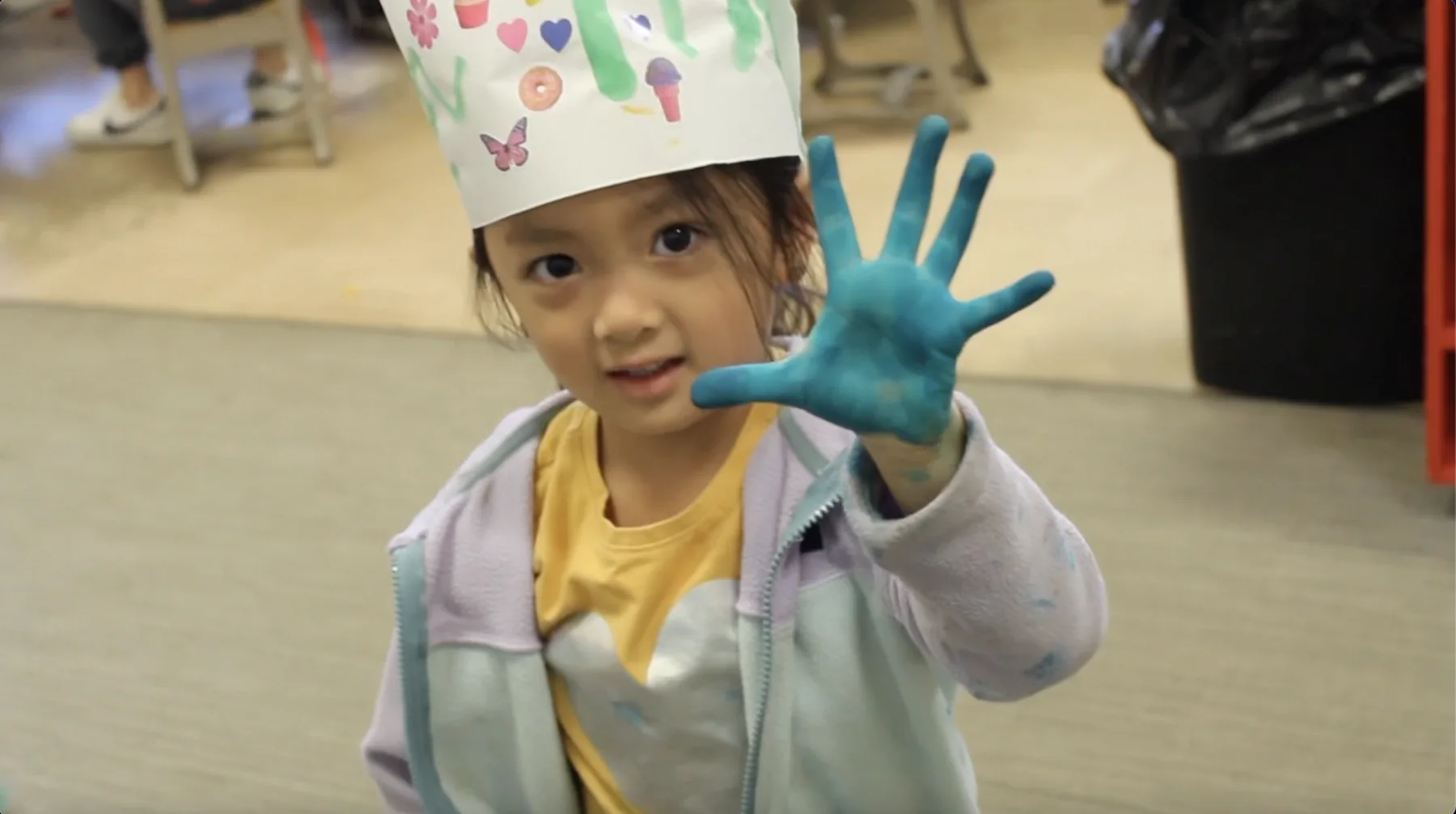 Discovery Parent-Child Preschool student showing a blue painted hand