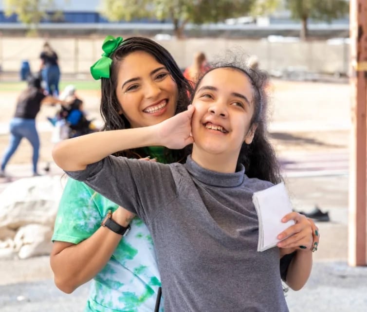 An ACCEL Phoenix student and staff member smile together outdoors