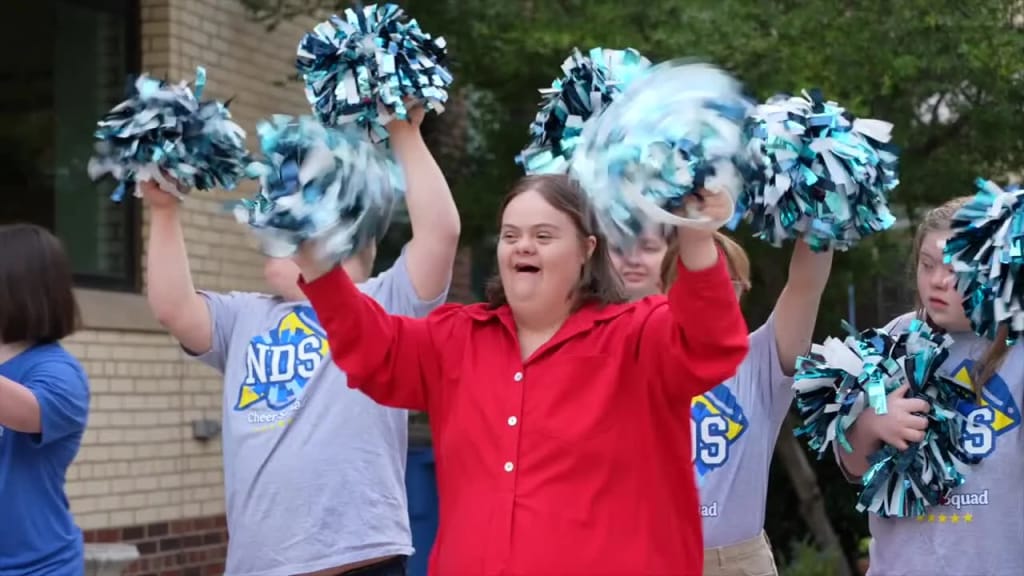 A Notre Dame School of Dallas student performs with pom-poms outdoors