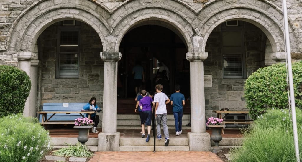 Baltimore Lab School students walking through the arched campus courtyard.