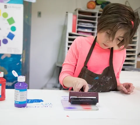 Baltimore Lab School student using a roller and paint during an art class.