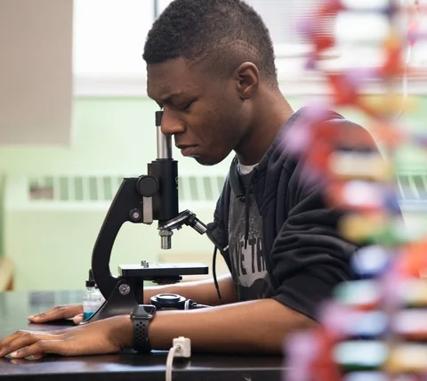 Baltimore Lab School student looking through a microscope during a science lesson.