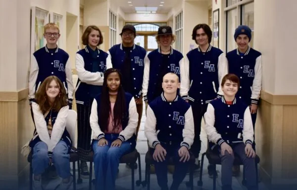 Group of Elizabeth Academy students wearing school jackets in a hallway.