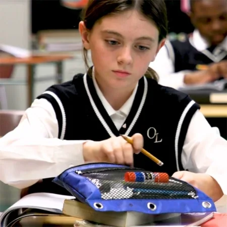 Our Lady of Lourdes School student works at a classroom desk.