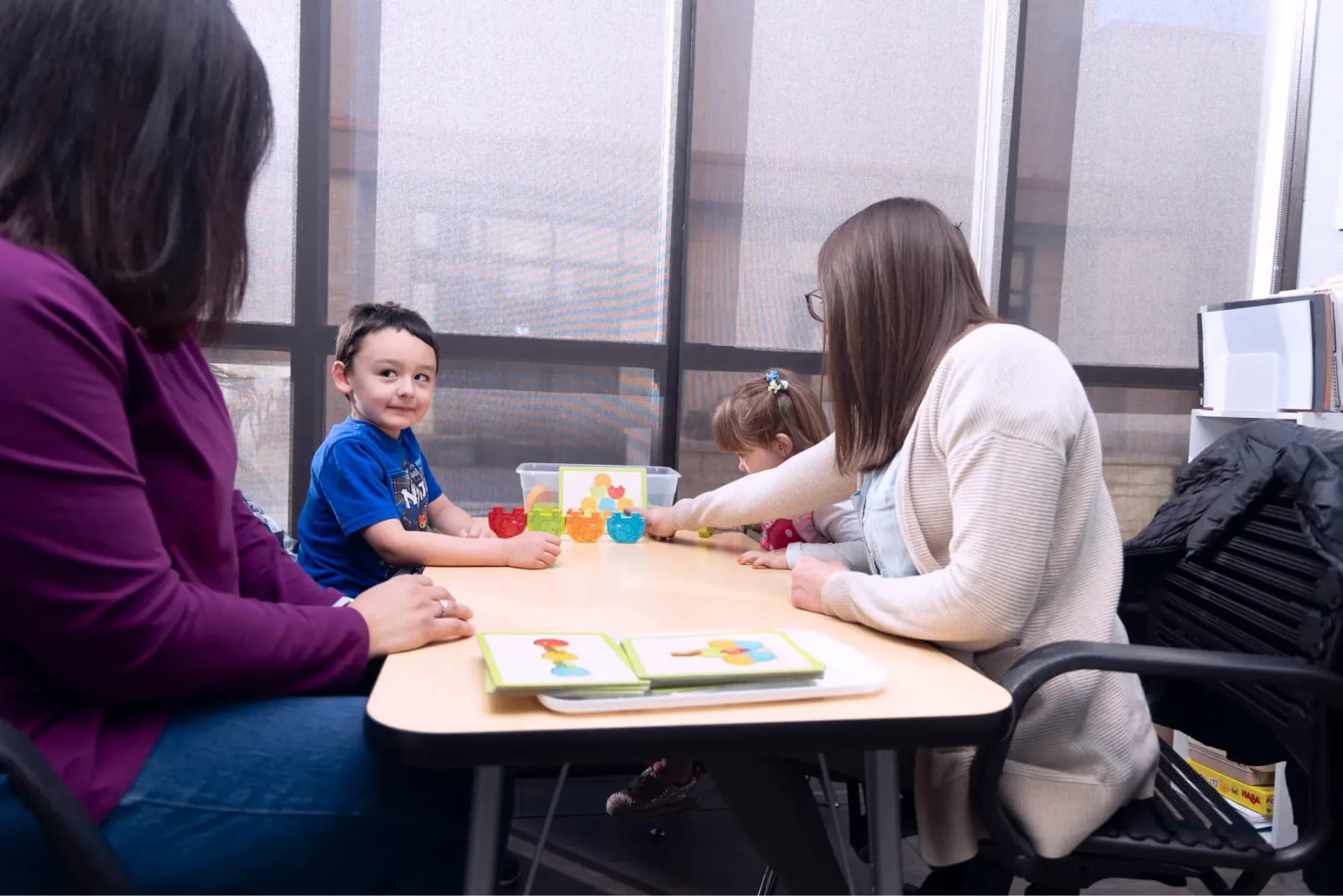 Adults and children working together at a table at Woven Care Pueblo North