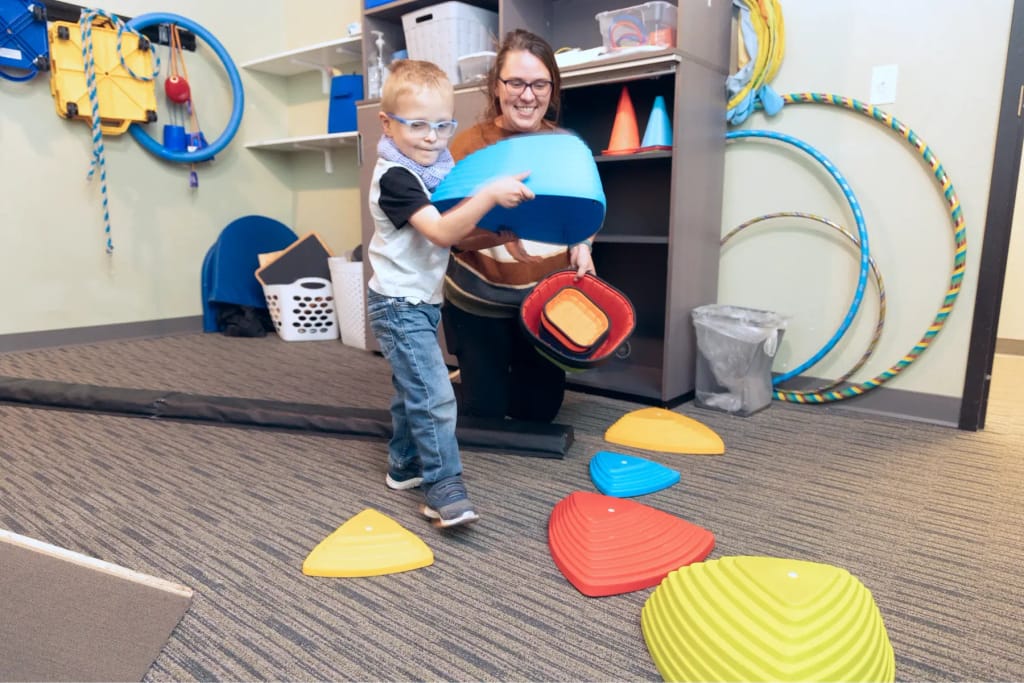 Child using colorful stepping equipment at Woven Care Pueblo North