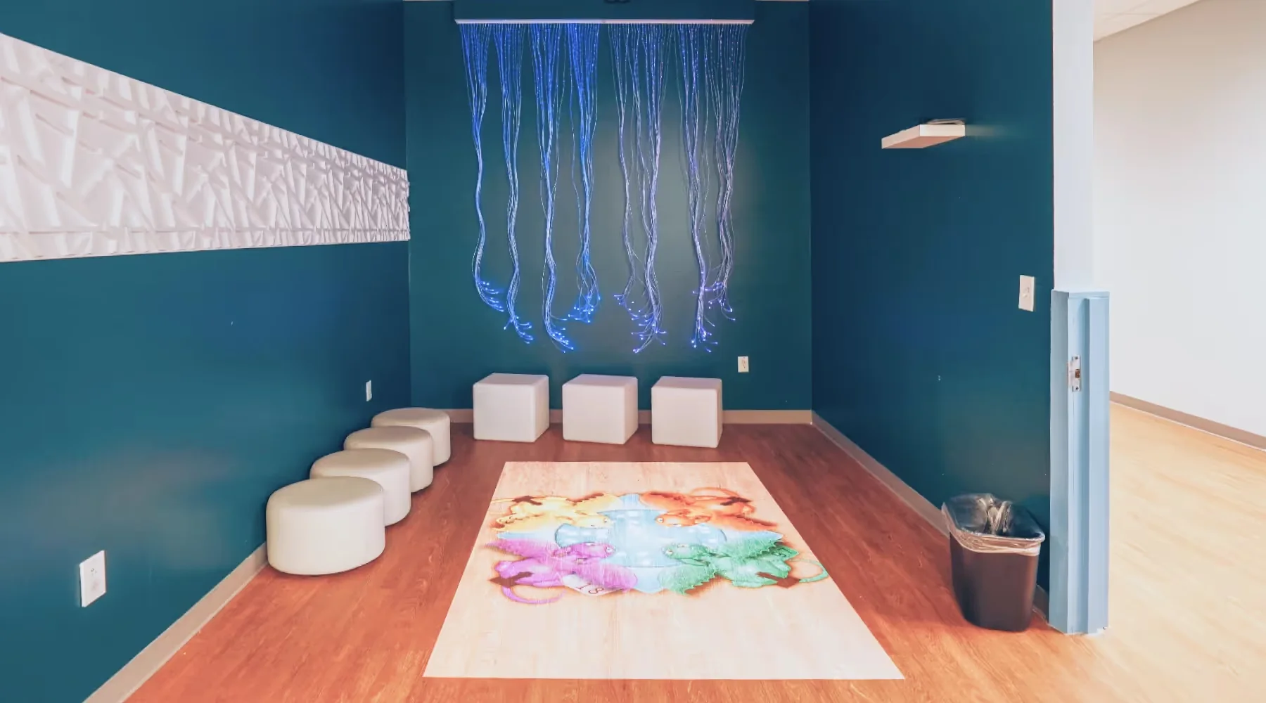 Indoor sensory activity room with floor seating and an art table at Action Behavior Centers.