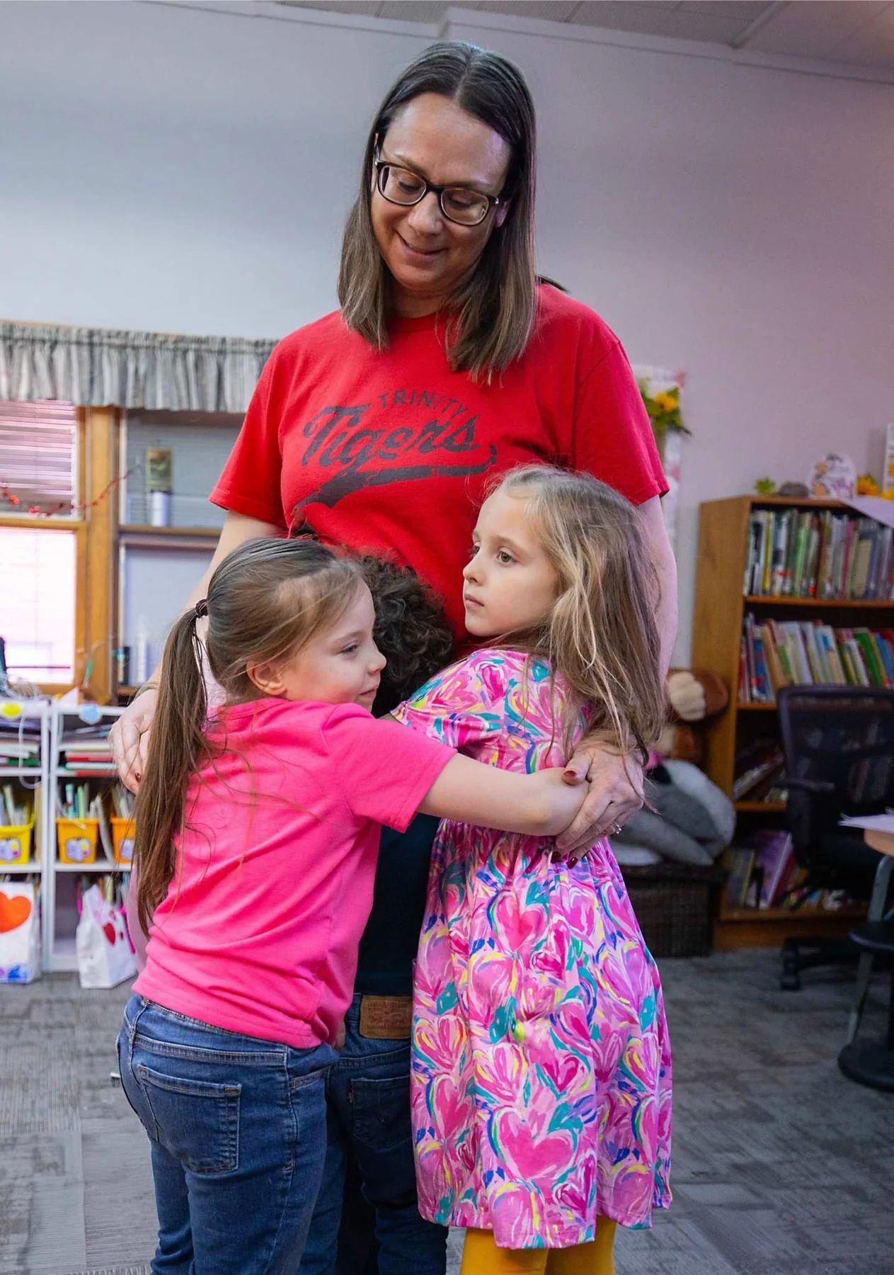 Trinity Lutheran School teacher greeting two young students