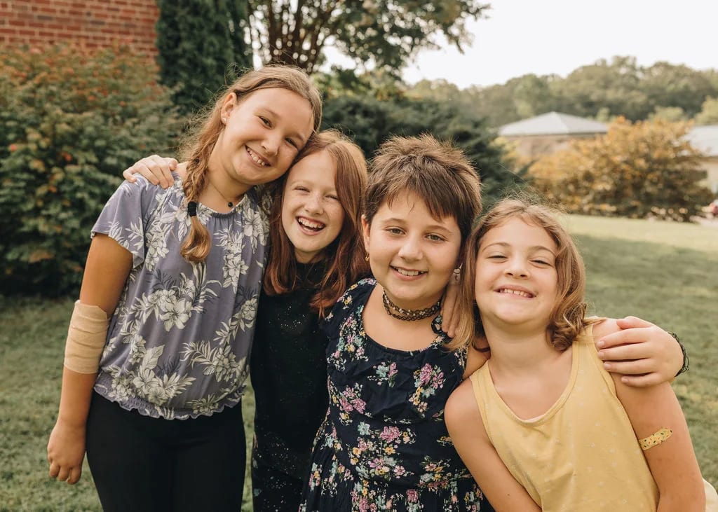 Asheville Waldorf School students sharing a hug outdoors.