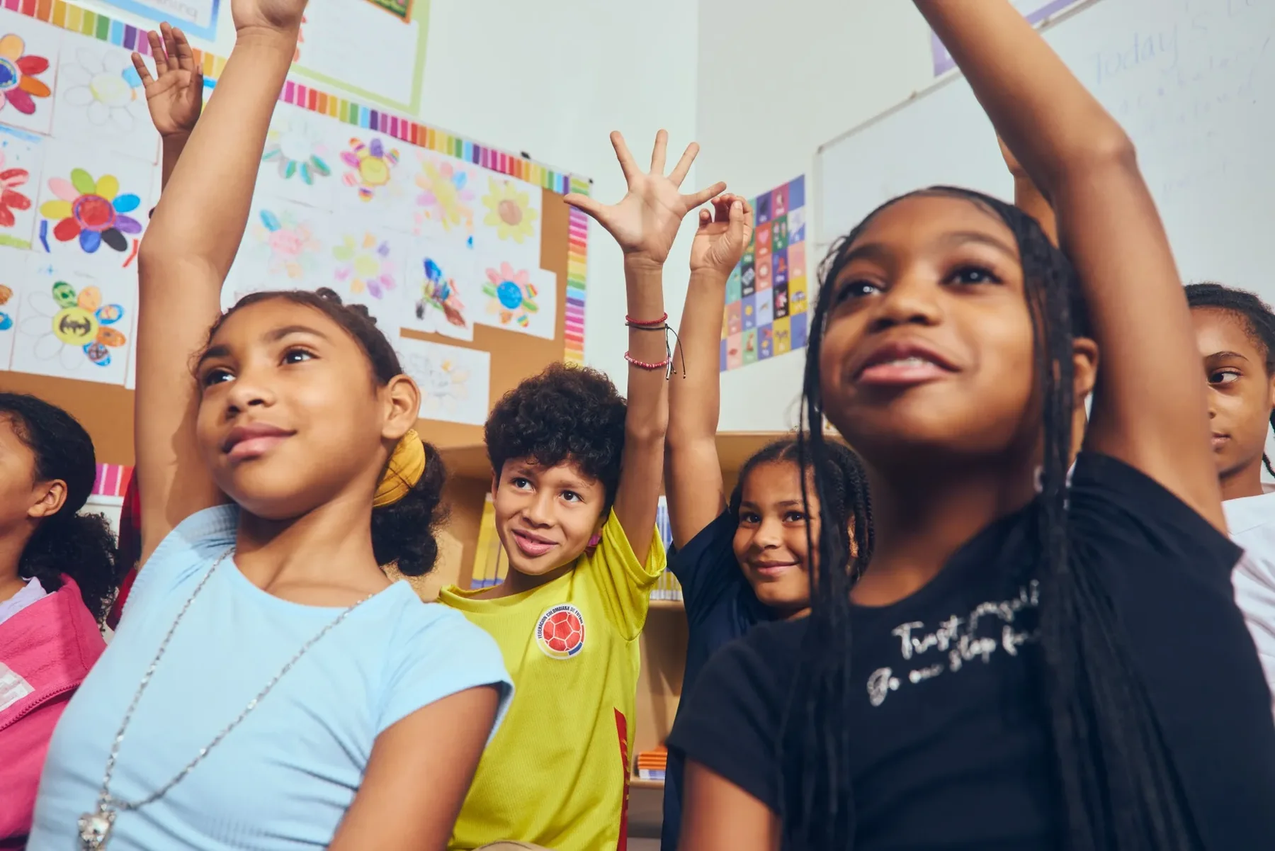 Primer Microschools students raising their hands during a group lesson