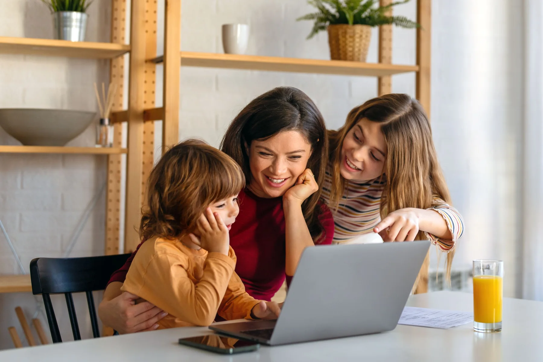 Adult and children using a laptop together at home
