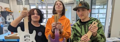 Newberg Catalyst High School students working on electric-guitar projects in a school lab.