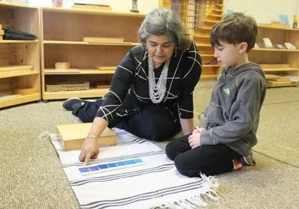 The Family Academy of Bethesda in Bethesda: teacher and child working with Montessori materials.