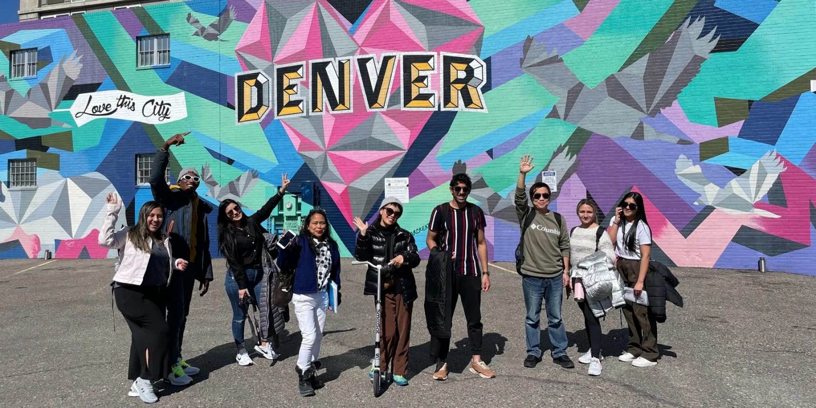 Colorado School of English students in front of a Denver mural