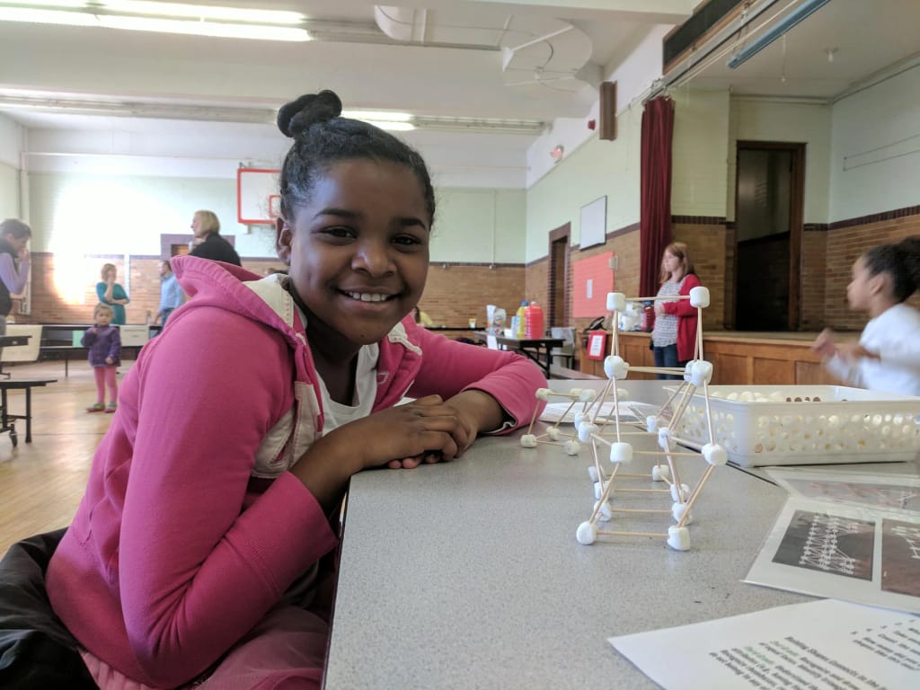 Grand Rapids Child Discovery Center student with a tabletop engineering activity.