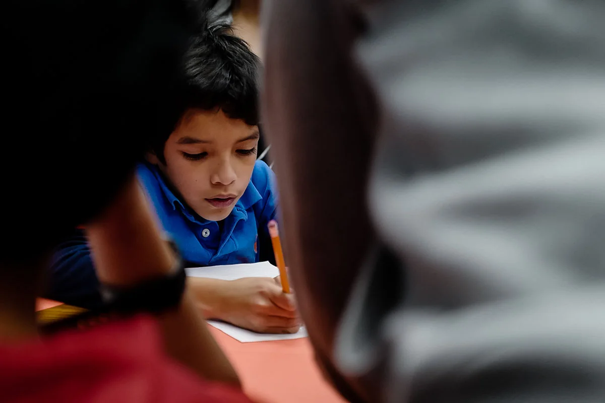 InBloom clinician supporting a child during an indoor learning activity.