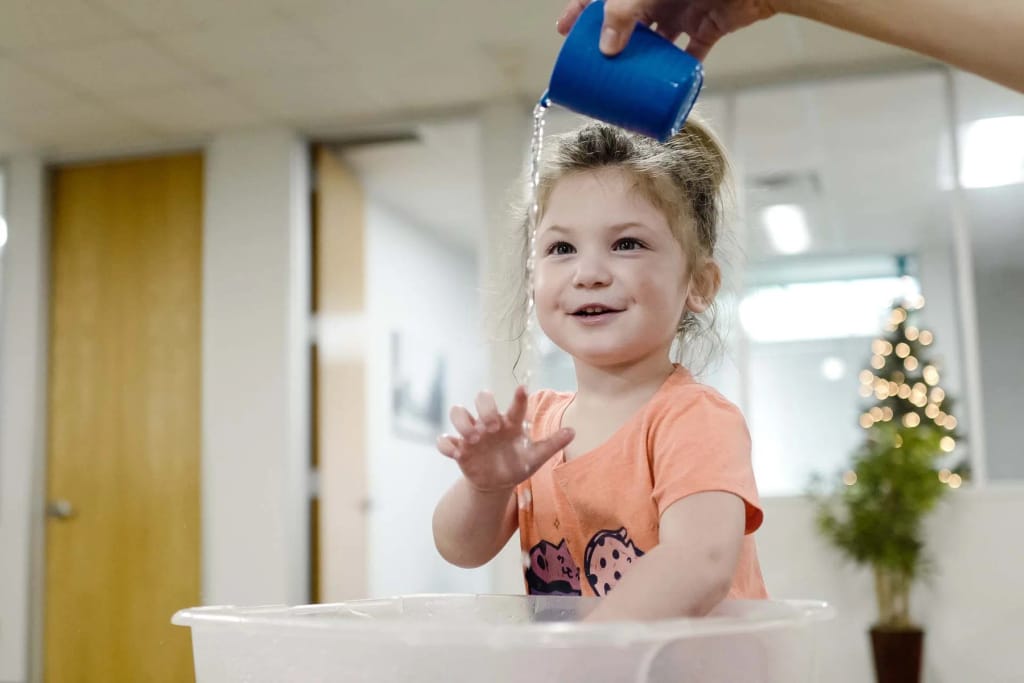 Child participating in an indoor daily-living activity at an InBloom therapy center.