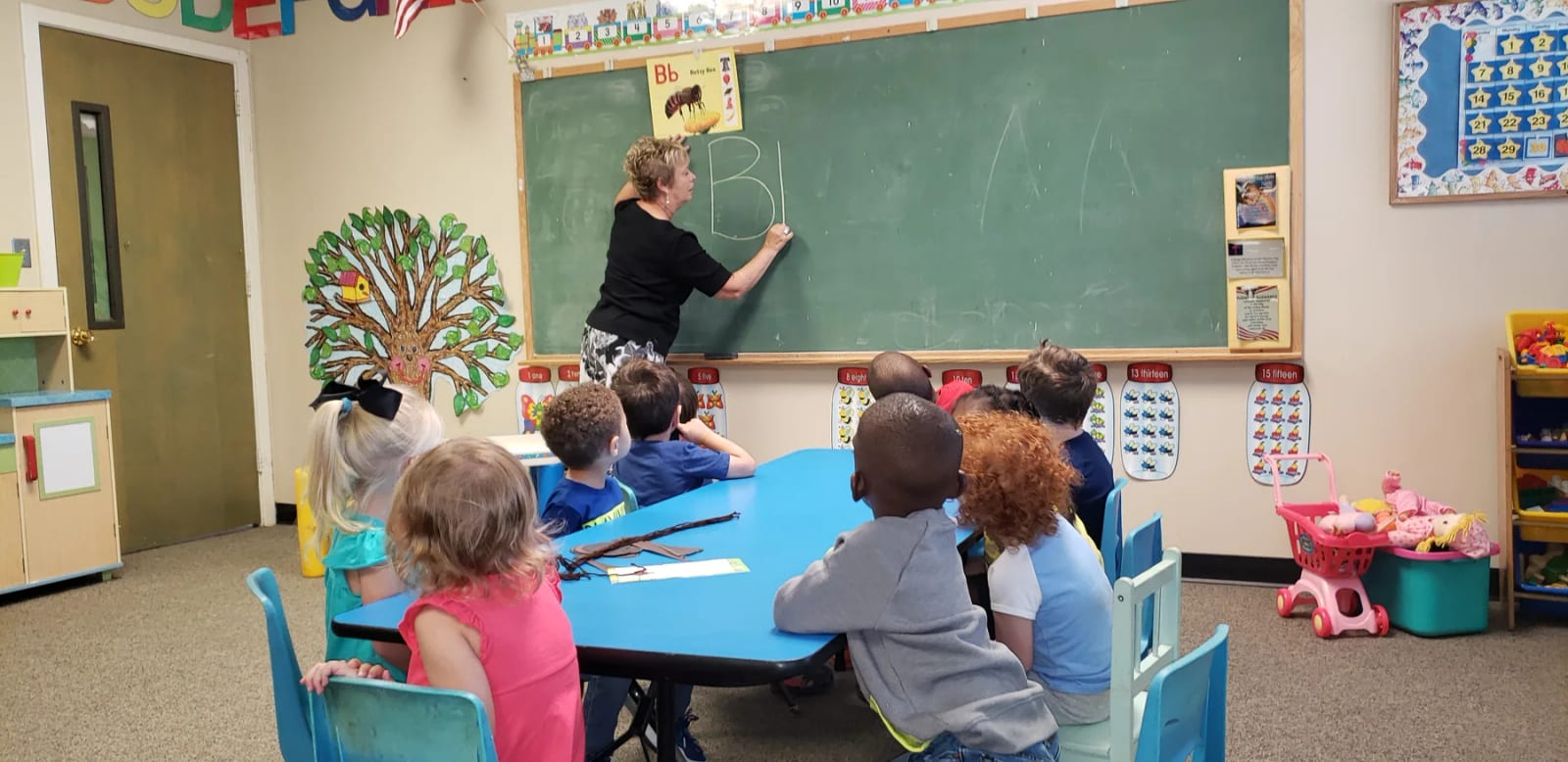 Children working together at tables in a PBC Preschool classroom.