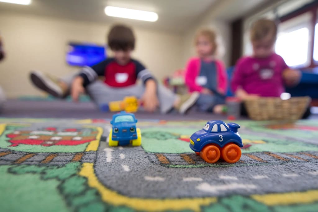 Toy cars and children in an indoor learning and play space