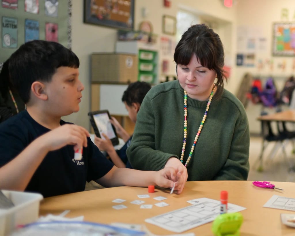 A Princeton House Charter School teacher works with a student at a classroom table